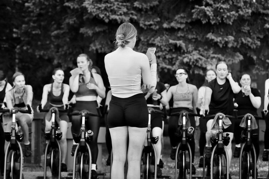 Members training together during a coached fitness session in black and white.